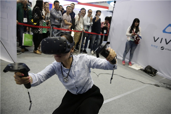 A woman plays a VR game provided by the VR device supplier HTC Vive at a mobile internet expo in Beijing.(DONG DALU/CHINA DAILY)