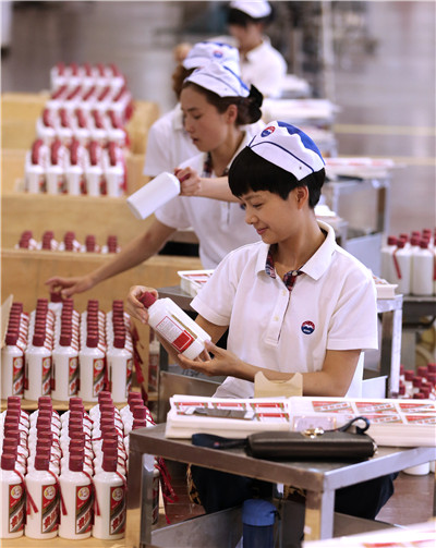 Workers at the production line of the famed baijiu Moutai at Moutai town in Guizhou province.(JIANG DONG/CHINA DAILY)