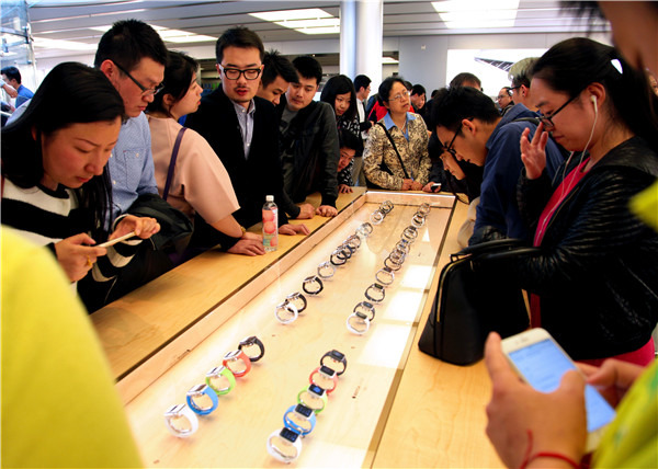 Consumers look at Apple watches in an Apple store in Shanghai. Apple Inc invested $1 billion in China's largest ride-hailing firm Didi Chuxing last week.(QIU DAOCEN/CHINA DAILY)