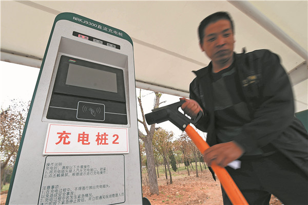 A car owner charges his new energy car at a newly opened charging post in Weifang, Shandong province, in April.WANG JILIN/CHINA DAILY