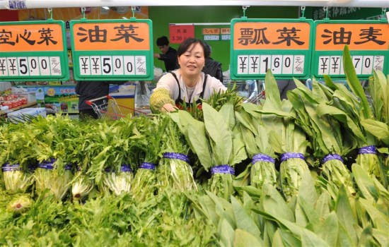 A vegetable vendor organizes her products inside a supermarket in Cangzhou City, north China's Hebei Province, April 10, 2016. (Photo: Xinhua/Mou Yu)