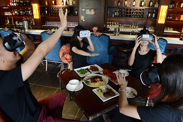 Customers experience VR glasses at a restaurant in Changsha, Hunan province. (Photo/China Daily)