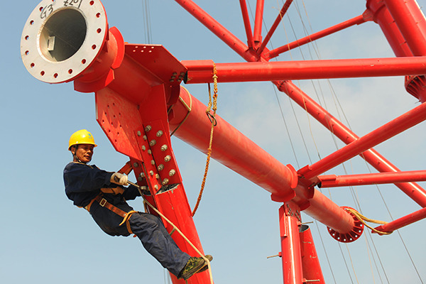 A State Grid employee works on an ultra-high-voltage transmission construction in Huainan, Anhui province. (Photo for China Daily by Song Weixing)