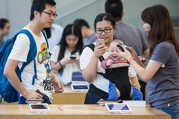 Customers try out products at an outlet of Apple Inc in Hangzhou, capital of Zhejiang province. (Photo/China Daily)