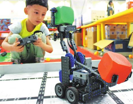 A child is attracted by a robot on display at a toy exhibition in Suzhou, Jiangsu province. (Wang Jiankang / for China Daily)