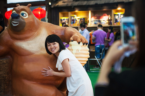 A girl takes a picture with a Boonie Bears character at the China (Shenzhen) International Cultural Industries Fair in Guangdong province in May. (Photo/Xinhua)