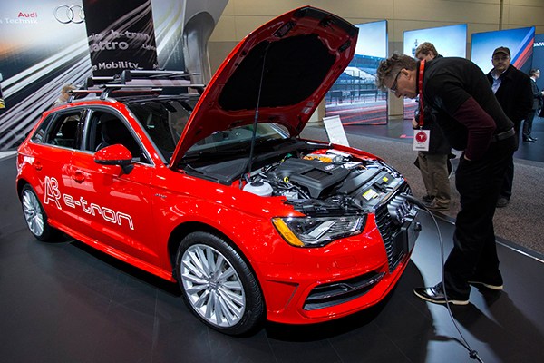 A visitor examines how a new-energy car is charged at an auto show in Toronto, Canada, in February. (Photo/Xinhua)