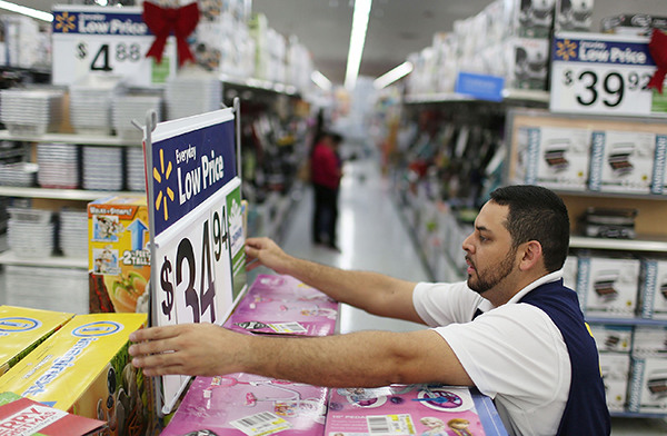 A man fixes a display in the aisle at a Wal-Mart store in Miami, Florida. (Photo provided to China Daily)