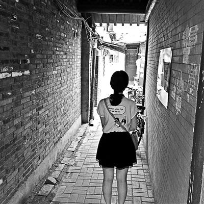 A woman walks through a shabby 10-square-meter hallway which is touted for 1.5 million yuan ($228,000) by a real estate company in Beijing. (Photo/Beijing Youth Daily)