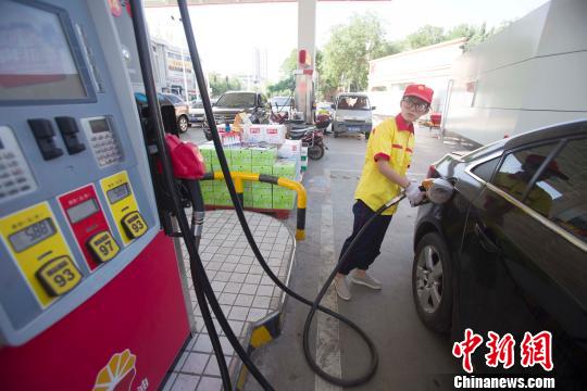A staff member fuels a car at a oil station in Taiyuan, Shanxi Province, June 23, 2016. (Photo/Chinanews.com)