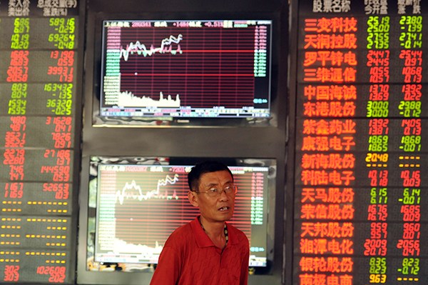 An investor checks stock prices at a securities brokerage in Fuyang, Anhui province. (Lu Qijian/For China Daily)