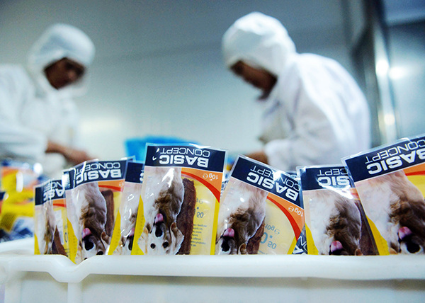 Workers pack dog food at a factory in Qingdao, Shandong province. The growth rate in the value of fast-moving consumer goods in China was 3.5 percent in 2015. (Yu Fangping/For China Daily)