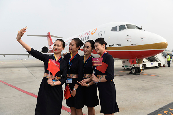 Flight attendants of Chengdu Airlines take a photo in front of the regional jet ARJ21-700 at Chengdu Shuangliu International Airport in Southwest China's Sichuan province on June 28, 2016. Photo/Xinhua