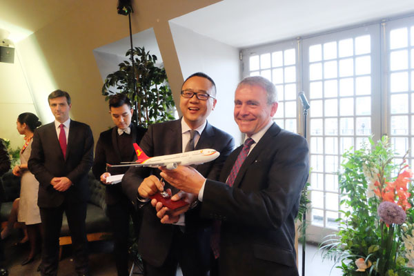 Executive Chairman and President of Tianjin Airlines Liu Lu presents a gift of a model aircraft to Minister of State Robert Goodwill at the Department for Transport. (Photo by Jiang Shan/China Daily)