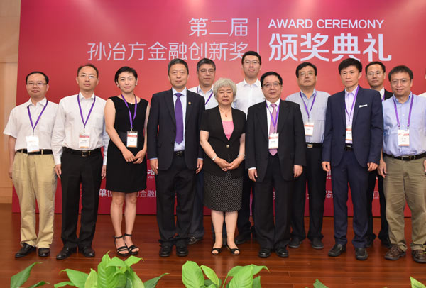 Winners of the Sun Yefang Financial Innovation Awards pose for a photo with Wu Xiaoling, (center in dress), top judge of the awards and dean of the Tsinghua University PBC School of Finance and next to her, Li Jiange, chairman of Sun Yefang Economic Science Foundation, on July 3, 2016 in Beijing. Winners include Liao Guanmin, (first from left), Gan Li (first from right), Liu Zheng (second from right) and Liu Xiliang (between Li Jiange and Liu Zheng). (Photo provided to chinadaily.com.cn)