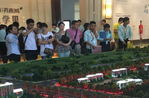 Prospective buyers look at a model of a residential real estate project on Saturday at the Guangyang Economic Development Zone in Langfang, North China's Hebei Province. (Photo: Li Xuanmin/GT)