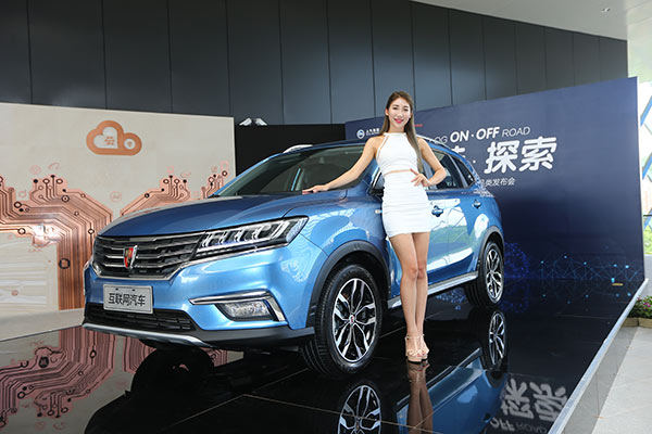 A model poses next to the OS'Car, an internet-enabled vehicle jointly developed by Alibaba and SAIC Motor Corp, on July 6, 2016 in Hangzhou, Zhejiang province . (Photo/China Daily)