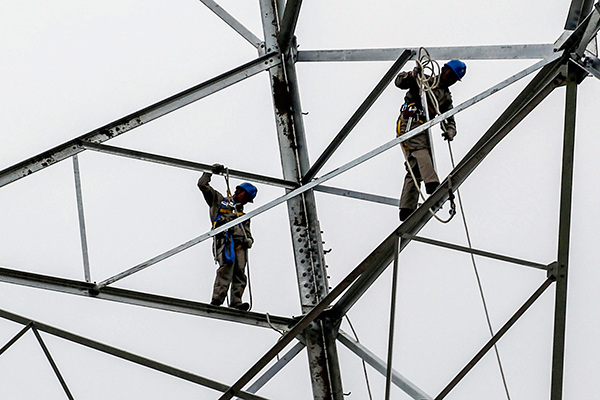 Workers install ultra-high-voltage transmission facilities that connect the Inner Mongolia autonomous region and Jiangsu province. (Photo/China Daily)