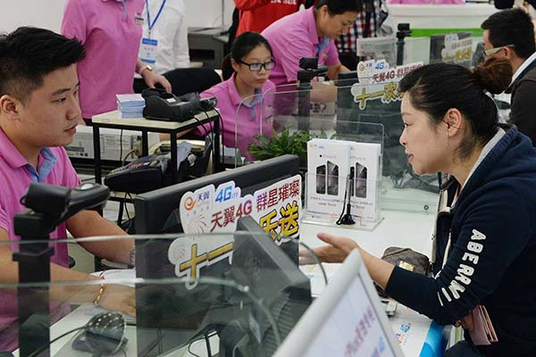 Customers buy smartphones at a China Telecom outlet in Shanghai. The telecom carrier is to launch a three-year plan to expand its presence in the countryside. LAI XINLIN / FOR CHINA DAILY