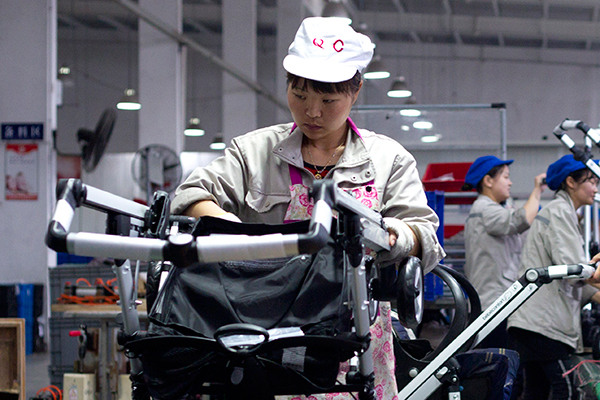 An employee of Goodbaby Group assembles baby strollers in the company's plant in Kunshan, Jiangsu province. (Photo/China Daily)