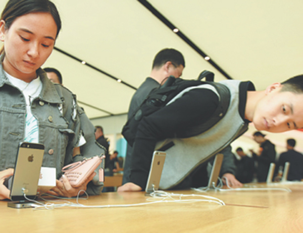 Customers try out iPhones at an Apple Inc store in Hangzhou, Zhejiang province. (Photo/China Daily)