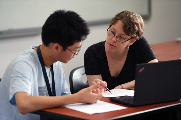 Anna De Vaul, a teacher from the United States, coaches a young Chinese student at Wenzhou-Kean University. (Photo by Wei Xiaohao/China Daily)
