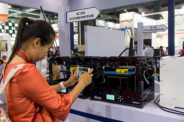 A visitor takes photo of a 3D printer at an expo in Shanghai, June 2, 2016. (Photo provided to China Daily)