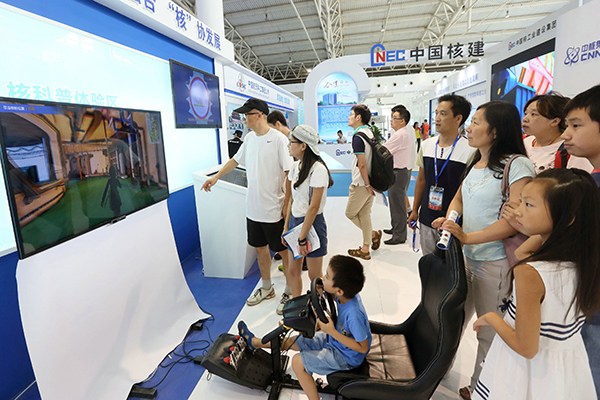 Visitors look at the stand of China National Nuclear Corp at an industry expo in Beijing. (Photo provided to China Daily)