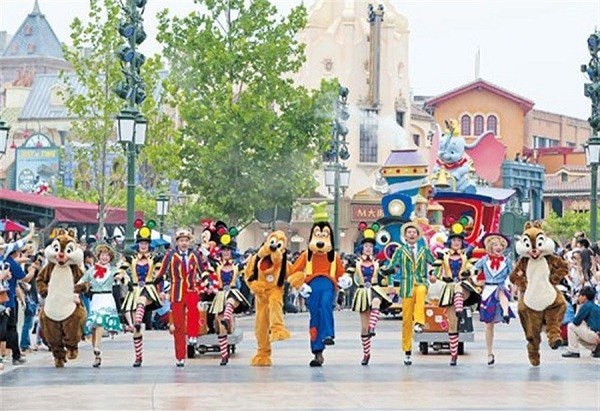 Tourists watch a parade, featuring some famous Disney animation characters, along the Mickey Avenue of Shanghai Disneyland yesterday. The Shanghai Disney Resort is to open today.(Xinhua)
