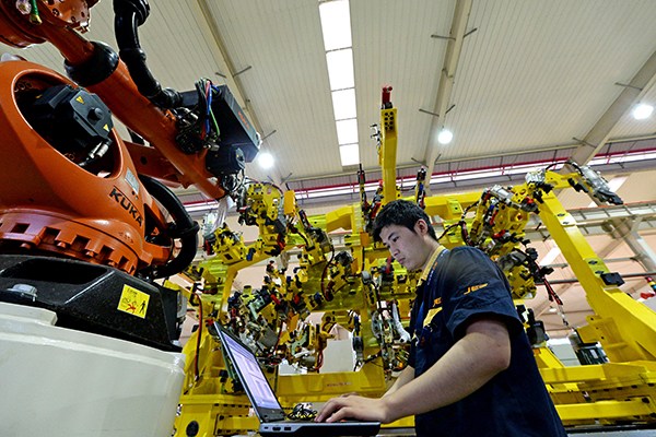 A technician writes the program for a robot bound for export in Hefei, capital of Anhui province. (Photo provided to China Daily)