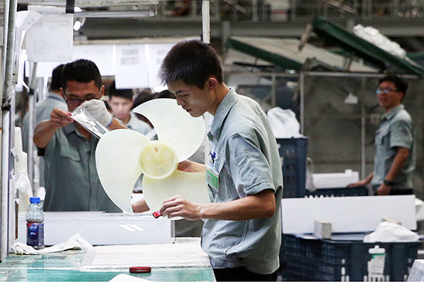 Gree employees produce air conditioner parts at the production line in the company's plant in Zhuhai, Guangdong province. (Photo/China Daily)