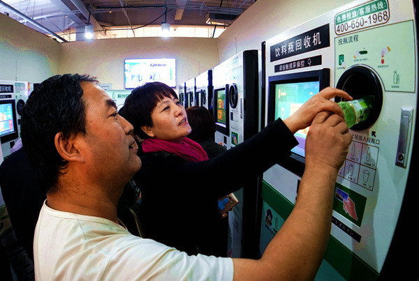 Beijing residents use an automatic recycling machine for plastic bottles in a supermarket in October.(Photo/Xinhua)