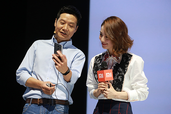 Lei Jun, CEO of Xiaomi Corp, tries Redmi Pro, a new Xiaomi handset released on Wednesday in Beijing, while actress Liu Shishi looks on. (Photo/China Daily)