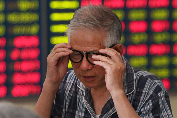An investor checks stock prices at a securities brokerage in Nantong, Jiangsu province. (Photo/China Daily)