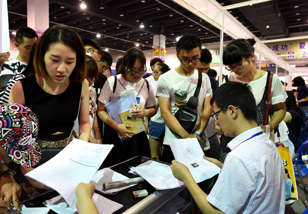 Jobseekers submit their resumes to prospective employers at a job fair in Yiwu, Zhejiang province. (PHOTO BY GONG XIANMING / CHINADAILY)