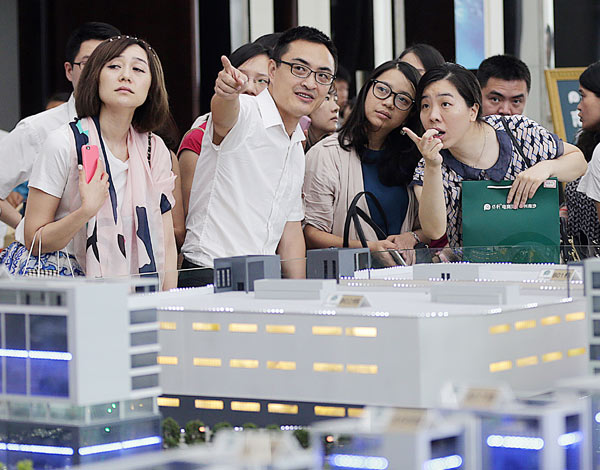 Prospective home-buyers appear keen at a housing project in Guangzhou. The shares of most of the listed real estate companies per-formed well in the first half of this year on the back of robust sales and growing home prices. (CHINA DAILY)