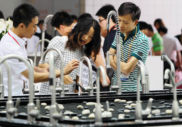 Consumers check the design and function of high-tech kitchen sinks at a consumer products expo in Shanghai.(Photo/Xinhua)