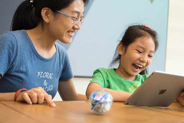 Photo taken on July 27, 2016 at an Apple Store shows a young girl and her mother play with an iPad Pro while participating the Apple Camp event held in Jinan, Shandong province. (Provided to chinadaily.com.cn)