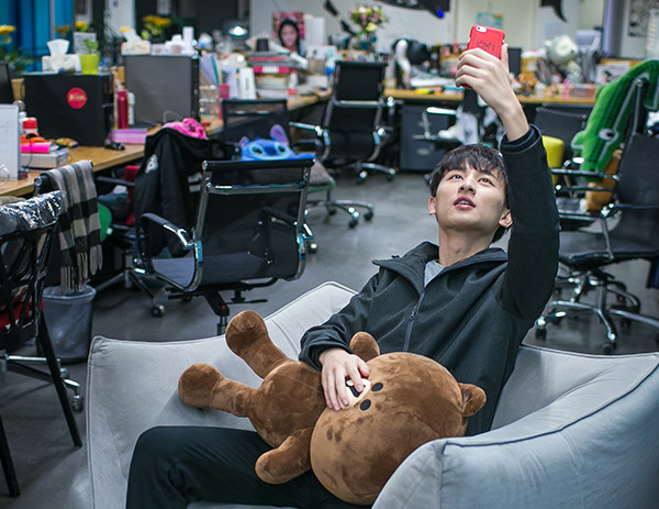 A young man makes a live-streaming show of himself at his office. (Chen Zhongqiu/For China Daily)