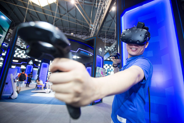 A visitor plays a VR-driven game for a 360-degree immersive experience at a recent tech fair in Shanghai. (XU KANGPING/CHINA DAILY)