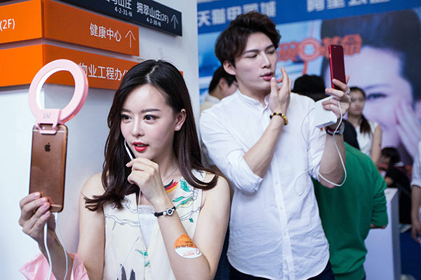 A woman and a man in a commercial live streaming event help sell essentials in Hangzhou, Zhejiang province. (Photo/China Daily)