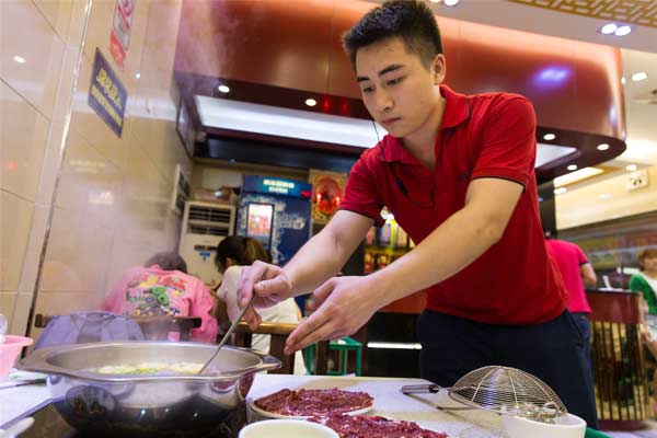 A restaurant attendant prepares beef for customers in Guangzhou, Guangdong province.(PROVIDED TO CHINA DAILY)