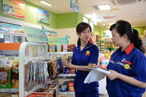 Two employees stack items at an EasyJoy convenience store in Jingdezhen, Jiangxi province.(Hu Qingming / for China Daily)