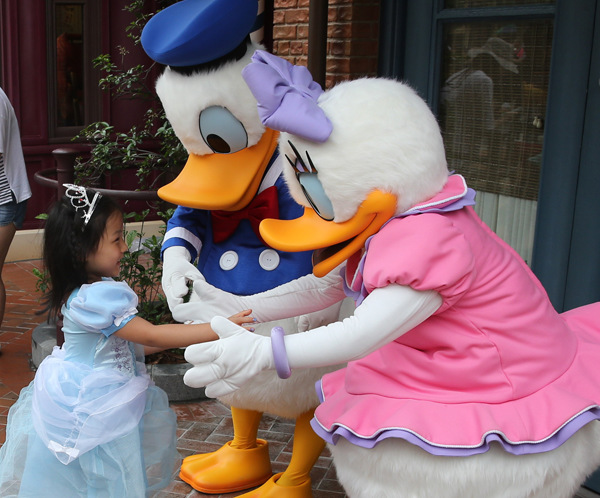 A girl meets her cartoon heroes at Shanghai Disneyland. (Photo/Xinhua)