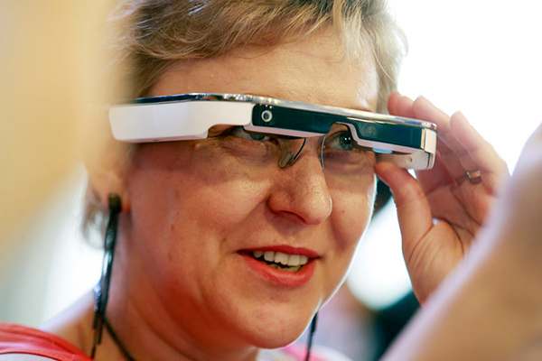 A visitor tries the Jianguan AR glasses at the launch of the product in Shanghai, July 9, 2016. (Photo by Zhu Xingxin/chinadaily.com.cn)