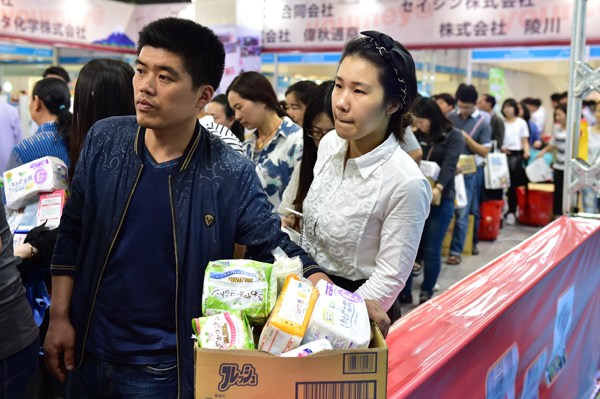 A couple wait in a queue to pay for some made-in-Japan baby diapers during a Japanese commodities fair in Yiwu, Zhejiang province. LV BING/CHINA DAILY