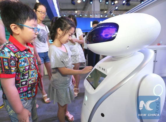 Children interact with a robot during an innovation, entrepreneurship and makers' achievement exhibition in Qingdao, east China's Shandong Province, July 31, 2016.(Xinhua/Liang Xiaopeng)