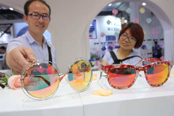 Vistors look at glasses on display at an expo in Beijing, Sept 9, 2015. (Photo provided to China Daily)
