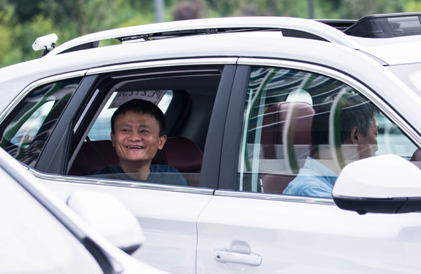 Jack Ma, founder and executive chairman of Alibaba Group Holding Ltd, sits in a newly launched sedan model of the Roewe RX5, an internet-connected SUV, jointly made by Alibaba and SAIC Motor Corp, last month in Hangzhou. (XU KANGPING/CHINA DAILY)