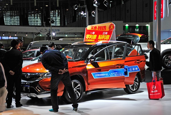 Visitors check out a new energy car at an energy conservation and new energy auto show in Nanjing in April. Xing Qu / For China Daily